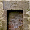 Portskewett church (Monmouthshire) has the plainest of all possible doorways in 
    its north wall, surmounted by a massive stone lintel inscribed with a double line suggesting a rounded arch, within which is carved a cross