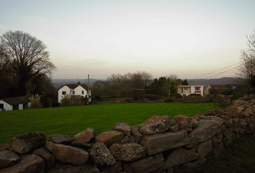 Image showing dispersed settlement with three houses and drystone wall in foreground.