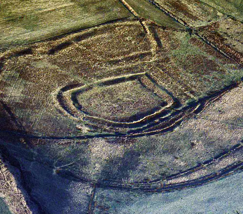 The concentric hillfort known as Y Bwlwarcau is surrounded by two or more ramparts, known as multivallate in archaeology. It lies on the eastern spur of Mynydd Margam east of Port Talbot. The earthworks show up well in this photograph under a low sun and a light dusting of snow.