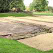 The forum (paved area) at Caerwent, with the foundations of the basilica behind.